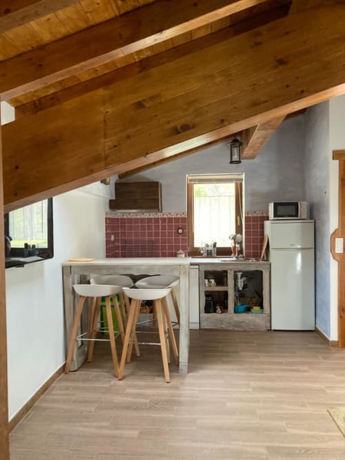 Cocina moderna en apartamento Casa Lafuente, Lukiano, con vigas de madera vista, barra, azulejos rojos y vistas a la montaña