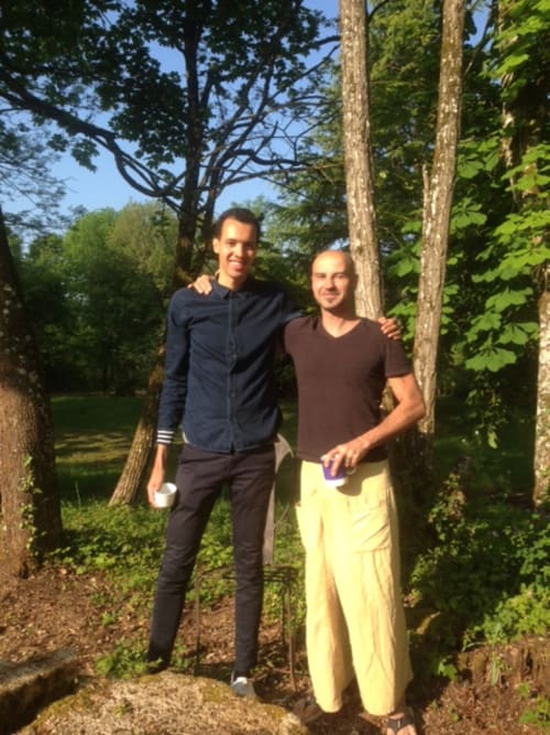 Gaël Faye & Gilles posant au Domaine de l'Ocrerie B&B à Pourrain, France, entourés de grands arbres