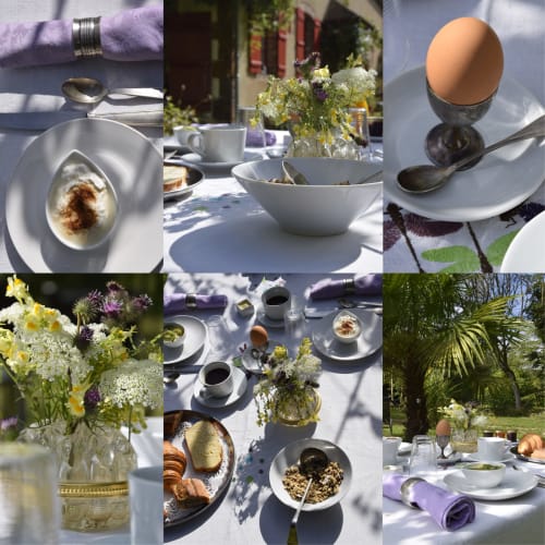 Elegante desayuno al aire libre en Domaine de l'Ocrerie con pasteles, huevo cocido, café y arreglos de flores silvestres