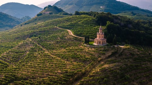 Vigneti terrazzati con cappella rosa nella regione del Treviso, paesaggio italiano vicino all'Apartment GioviGemini