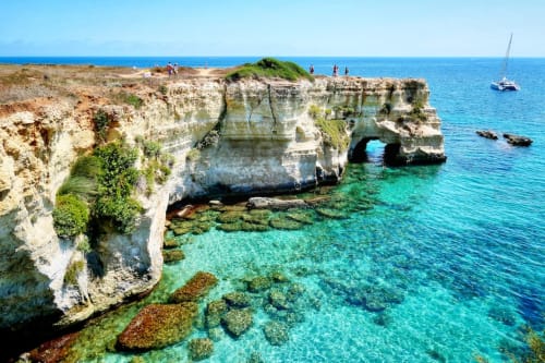 Impressionnantes falaises blanches de calcaire avec arche naturelle surplombant les eaux turquoise près d'Acaya, Italie