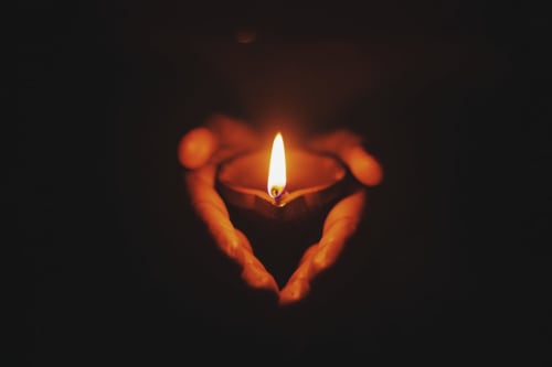 Hands forming heart shape around lit candle at Domaine de l'Ocrerie, Pourrain