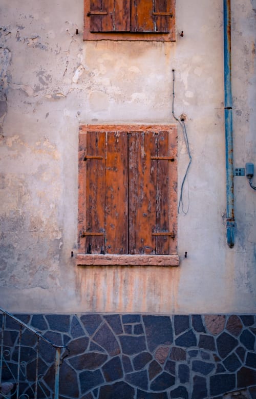 Fenêtre en bois aux volets rustiques sur mur en plâtre usé à la Masseria Vittoria, Acaya, Italie