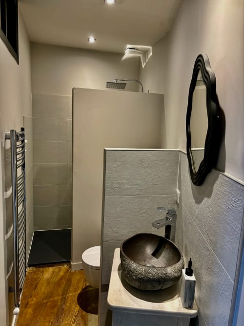Salle de bains moderne dans la chambre Pierre de Ronsard du gîte La vie de château à Grignan, avec lavabo en pierre et douche