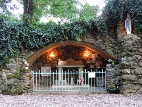Steingrotte-Heiligtum mit weißem Tor auf dem Domaine de l'Ocrerie Gästehaus in Pourrain, Frankreich