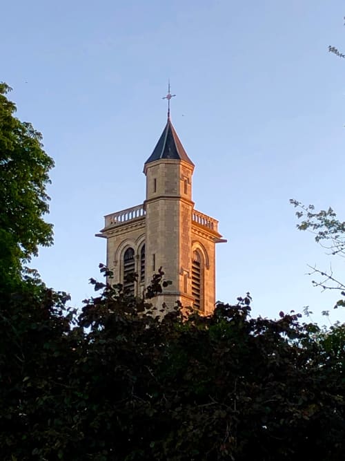 Historischer Kirchturm auf dem Domaine de l'Ocrerie in Pourrain, Frankreich, mit goldener Steinarchitektur und Kreuz