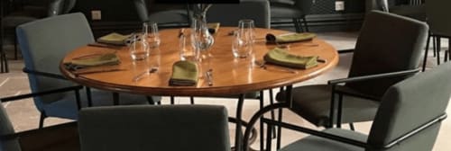 Elegant round wooden dining table set for guests at Domaine de l'Ocrerie, a French bed and breakfast in Pourrain, with place