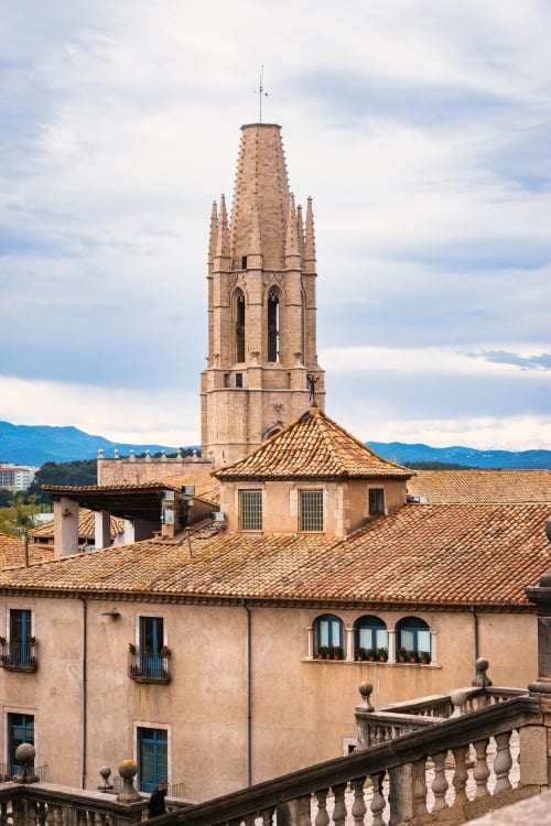 Torre medieval y tejados de barro de la propiedad vacacional L'Estartit en España con montañas al fondo