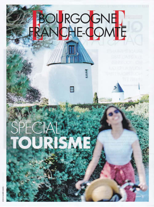 Femme dans les vignes de Bourgogne Franche-Comté avec ancien moulin derrière les haies