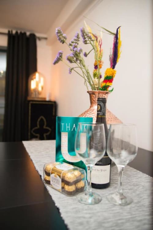 Welcome amenities display at Dublin Exchange Suites with wine, treats, flowers, and thank you gift bag on dining table