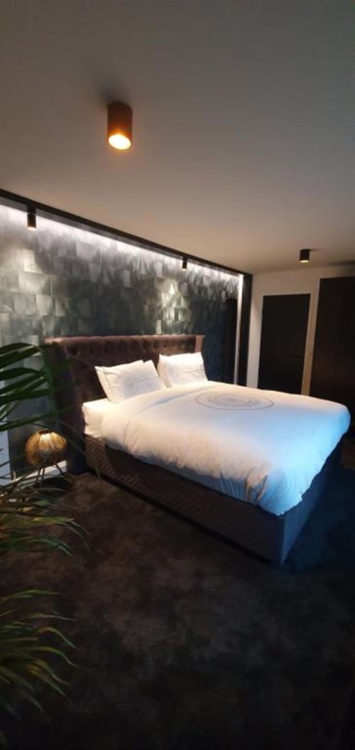 Contemporary bedroom suite at Dublin Exchange Suites with queen bed, garden view window, warm lighting, and modern decor
