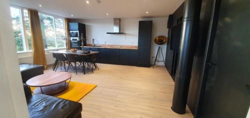 Modern open-plan kitchen and living area in Dublin Exchange Suites contemporary suite with black cabinetry, stainless steel