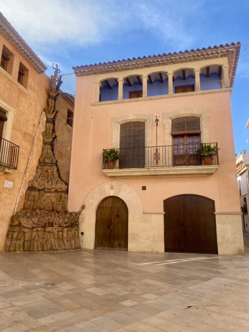 Edificio histórico de terracota con contraventanas azules en Altafulla, España en BondBeach Village