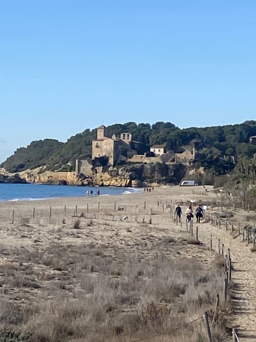 Hotel beachfront BondBeach Village en Altafulla con ruinas de castillo medieval frente a playa de arena y aguas turquesas