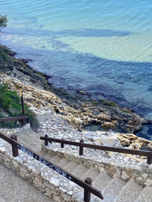 Mirador costero de BondBeach Village Altafulla con costa rocosa, aguas turquesas del Mediterráneo y barandillas de madera