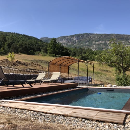 Piscine avec vue sur les montagnes à Entre Terre Et Ciel, maison d'hôtes à Rémuzat, France, avec transats et pergola