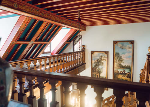 Élégant escalier en bois aux rampes ornementales du Domaine de Bize, orné de plafond décoratif et peintures paysagères