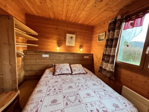 Chambre cosy en bois du chalet Chamois aux Gîtes Des Planchettes, Marigny, avec lit queen-size et vue montagne