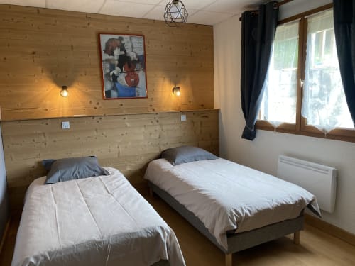 Chambre twin du gîte Le Hérisson aux Gîtes Des Planchettes, Marigny, avec murs en bois et lumière naturelle