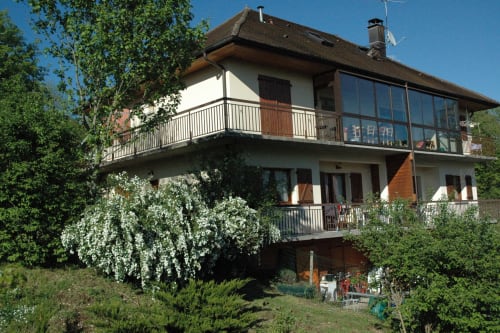 Cottage Gîtes Des Planchettes à Marigny : façade blanche, balcons métalliques, jardin luxuriant