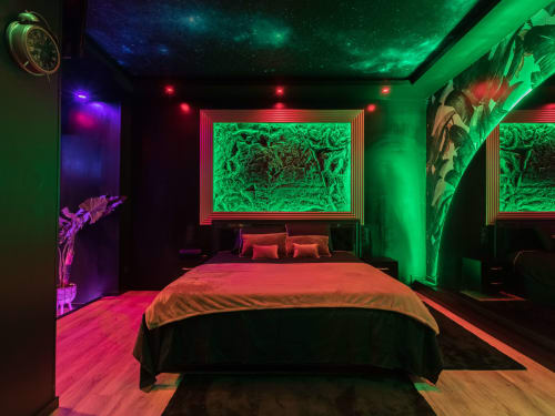 Chambre contemporaine à L'Insolite Spa Privatif à Toulouse, éclairage néon vert, lit rouge et œuvres d'art encadrées