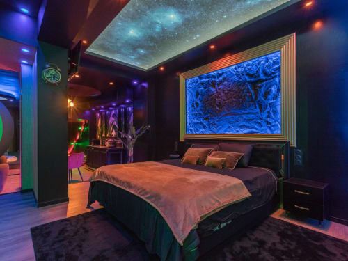 Chambre de luxe contemporaine à L'Insolite Spa à Toulouse avec éclairage néon, plafond étoilé, œuvre d'art illuminée en bleu