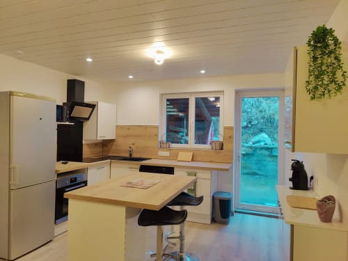 Cuisine moderne avec îlot, comptoirs en bois et vue sur les montagnes à l'appartement MarjoRI du Lauzet-Ubaye