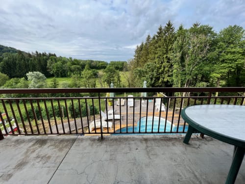 Vue de la terrasse de la piscine surplombant les forêts verdoyantes du Gîtes Des Planchettes à Marigny, France