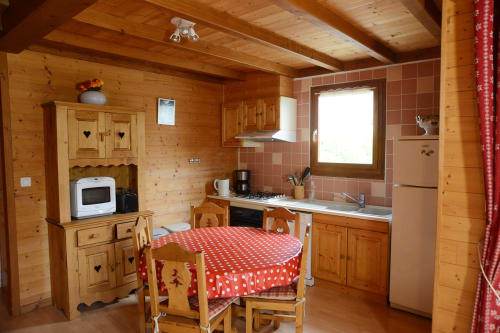 Cuisine rustique en bois au chalet Lynx des Gîtes Des Planchettes à Marigny, avec nappe à pois rouges et décor traditionnel