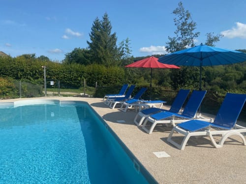 Piscine des Gîtes Des Planchettes à Marigny avec transats bleus et parasols