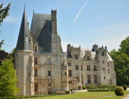 Grand château de pierre avec tourelles entouré de jardins aménagés à Vienne-en-Bessin, France