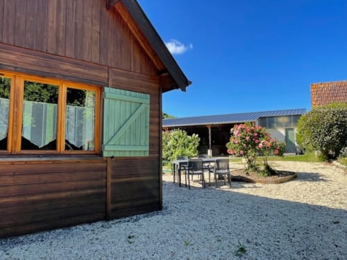Le chalet Rainette, façade en bois, vue sur le jardin et cour en gravier aux Gîtes Les Rainettes