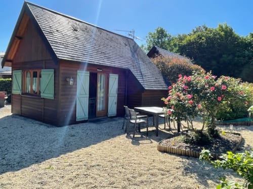 Le chalet Rainette aux Gîtes Les Rainettes à Vienne-en-Bessin avec patio, roses roses et mobilier extérieur