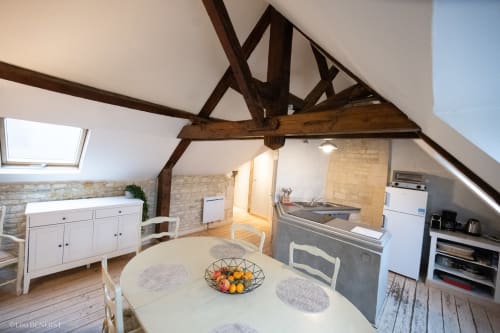 Cuisine spacieuse et salle à manger de la Fraternité Loft à la Villa République à Caen, avec poutres apparentes, puits de lumière et style contemporain