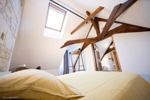Chambre spacieuse Fraternité Loft avec poutres apparentes, puits de lumière, literie jaune et miroir à Villa République à Caen