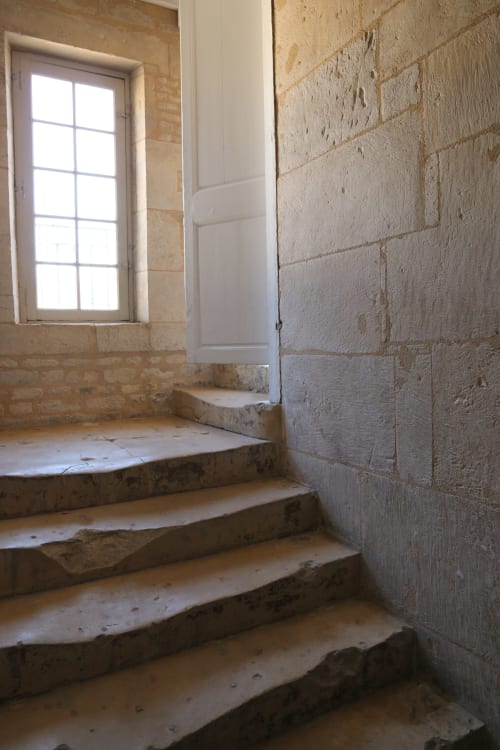 Escalier en pierre avec porte blanche et fenêtre dans un appartement historique à Caen, Villa République Normandie