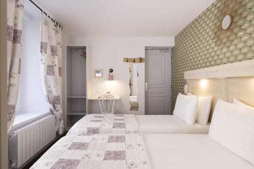 Chambre Twin standard à l'Hôtel De Lion Sur Mer avec deux lits, papier peint à motifs, espace de travail et équipements modernes à Lion