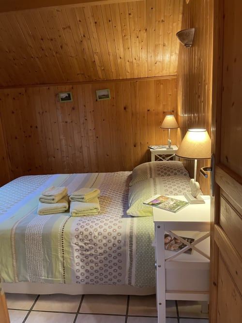 Chambre douillette au chalet Rainette des Gîtes Les Rainettes à Vienne-en-Bessin, avec boiseries et vue sur le jardin