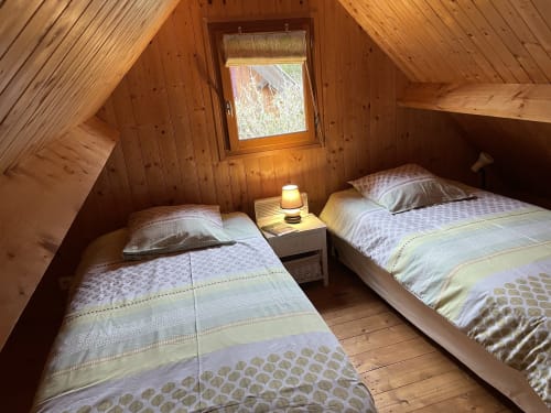 Chambre cosy du chalet en bois avec lits jumeaux aux Gîtes Les Rainettes, Vienne-en-Bessin