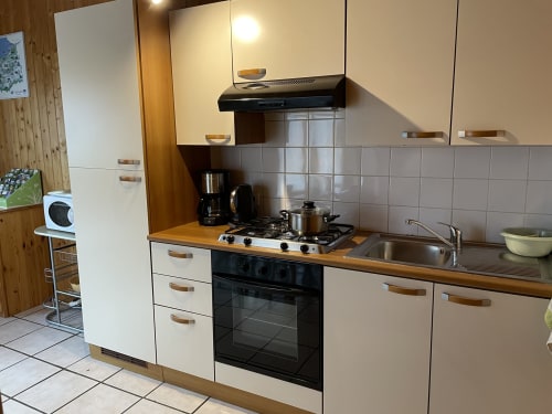 Cuisine moderne du chalet Rainette aux Gîtes Les Rainettes à Vienne-en-Bessin, avec cuisinière à gaz et comptoirs en bois