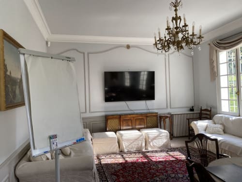 Elegante sala de seminarios en el Domaine de Bize Mirepoix con pizarra, televisor, araña de luces y asientos cómodos en Ariège, Francia