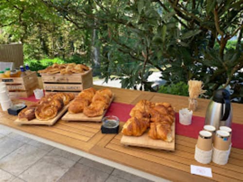 Desayuno al aire libre con croissants y café en Domaine de Bize, en un jardín con árboles