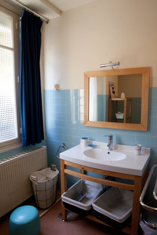 Salle de bain du gîte La Maison de Lise aux Chambres d'hôtes Les Pratges à Figeac, avec meuble vasque et miroir en bois