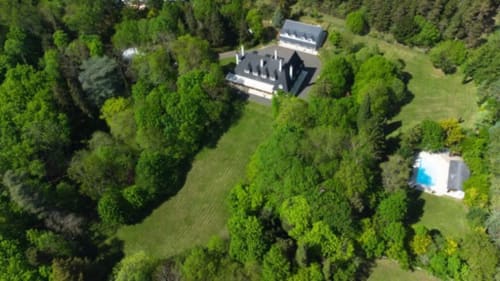 Aerial view of Domaine de Bize manor surrounded by lush gardens and forest in Mirepoix, Ariège