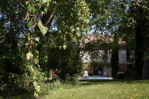 Grange d'Andressac aux Pratges B&B à Figeac, vue sur la piscine à travers le jardin et la pelouse bordés d'arbres