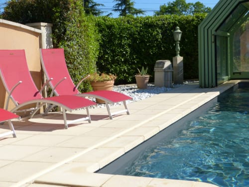Pink loungers by clear swimming pool at Villa Thébaïde cottage in Laudun L'Ardoise, with garden and terrace