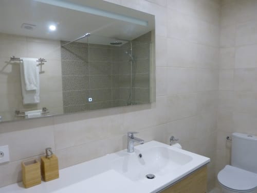 Modern bathroom at Villa Thébaïde with white sink, large mirror, walk-in shower, and toilet in Laudun L'Ardoise