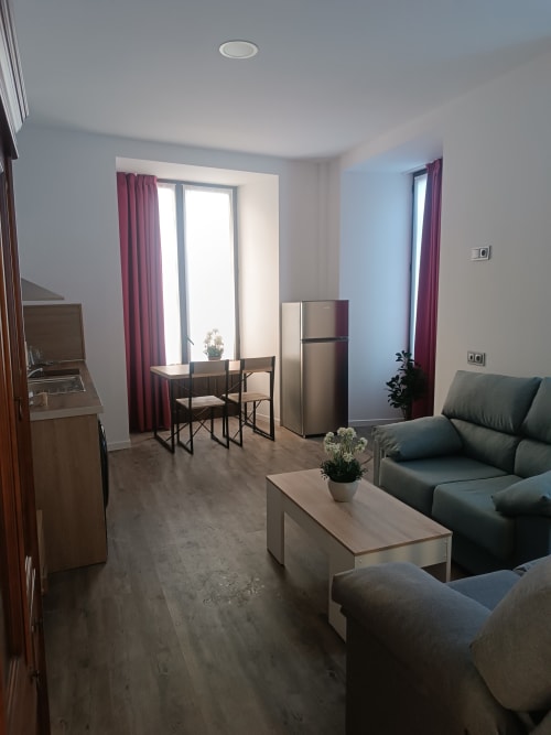 Moderno estudio en Ávila con sala de estar, cocina americana, sofá y escritorio