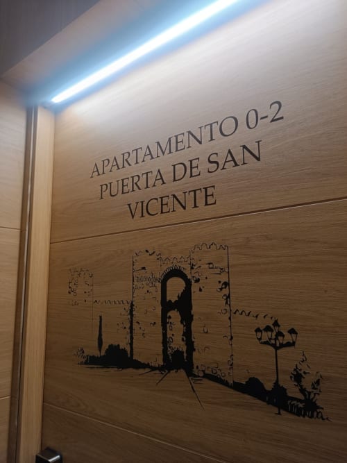 Letrero de puerta Apartamento 0-2 en Puerta de San Vicente en Ávila con ilustración del castillo medieval