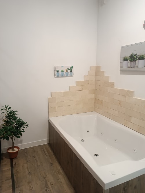 Baño moderno en Apartamentos Turísticos Ávila con azulejos tipo metro crema, bañera blanca, plantas en macetas y